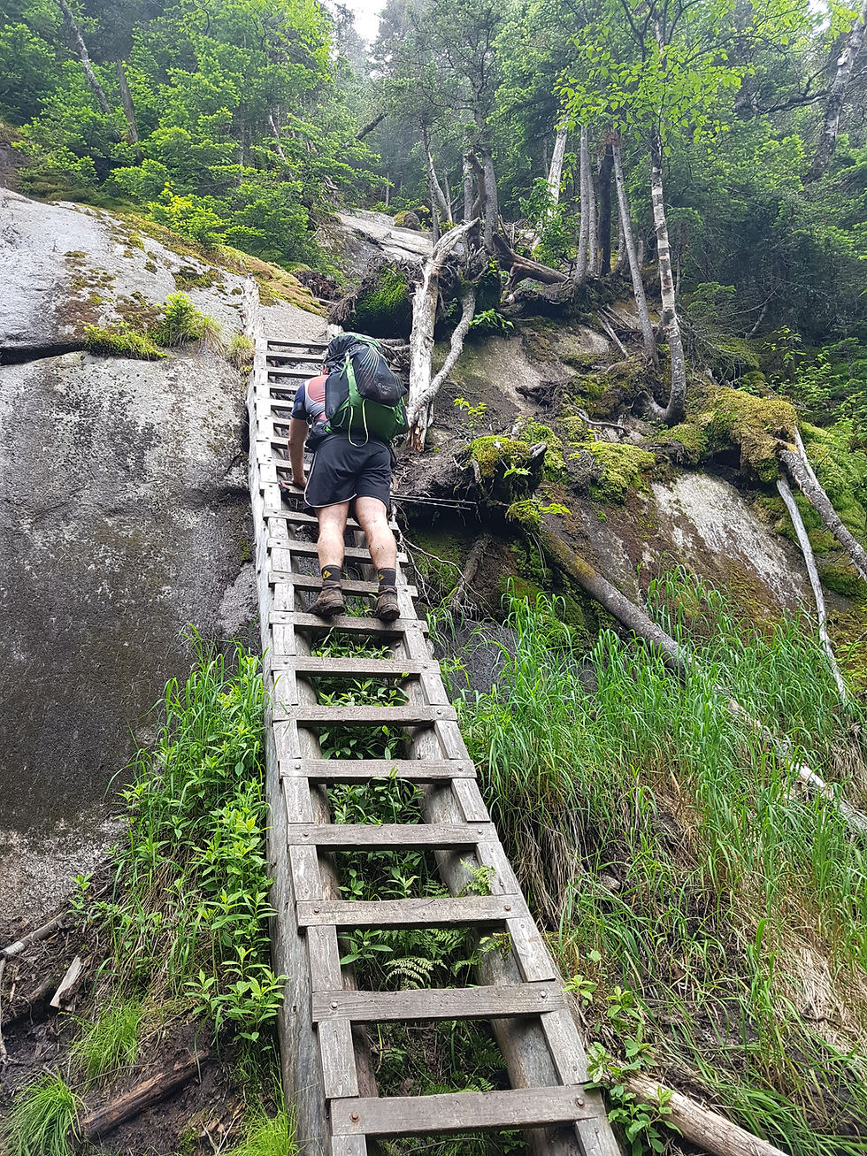 Climbing a wooden ladder up a cliff