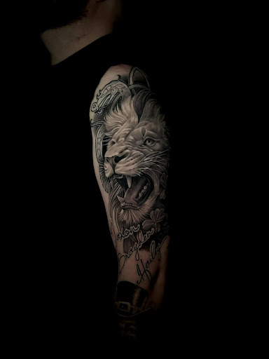Black-and-grey roaring lion portrait with ornamental framing and script