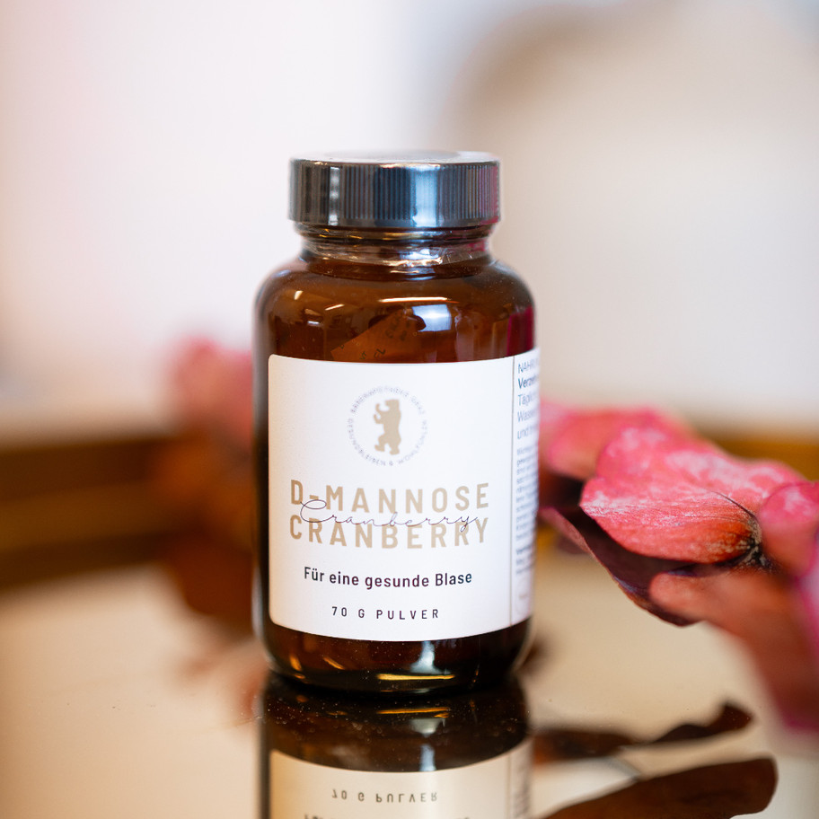 D-Mannose Cranberry Pulver zur unterstützenden Behandlung einer Blasenentzündung auf einem goldenen Tablett präentiert.