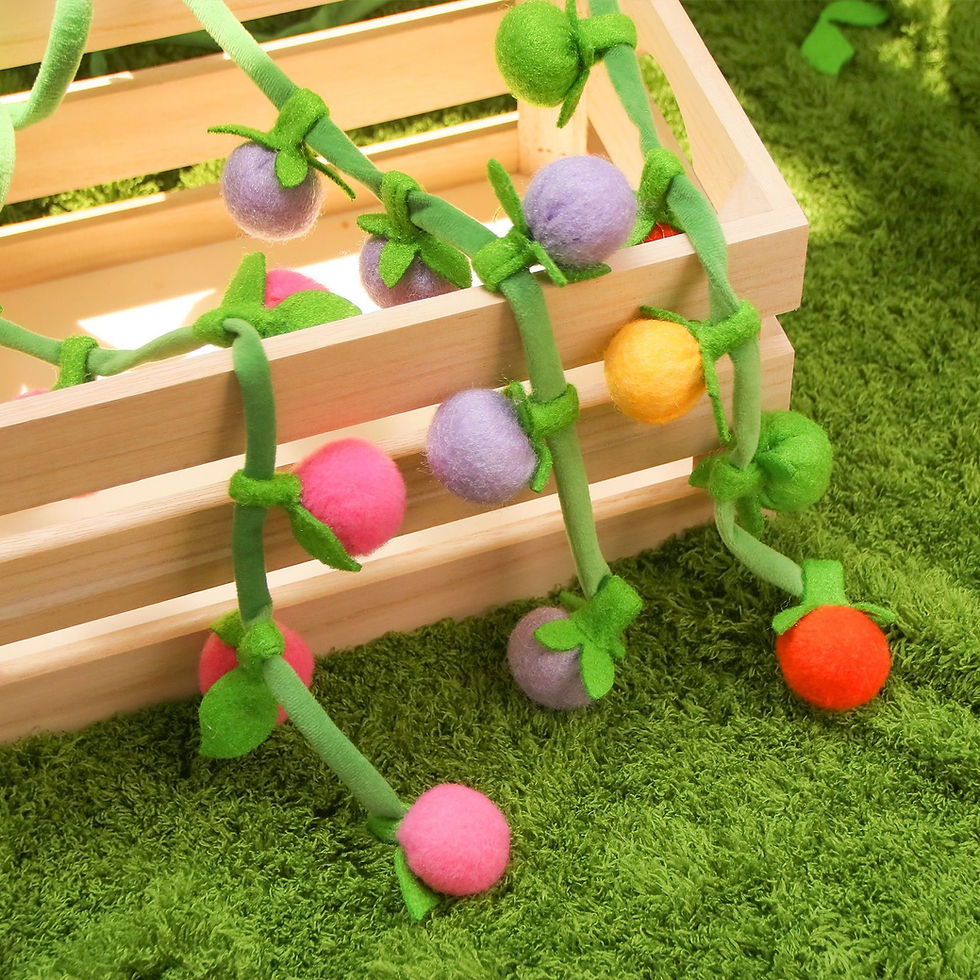 Colorful hanging catnip ball toys on green vines.