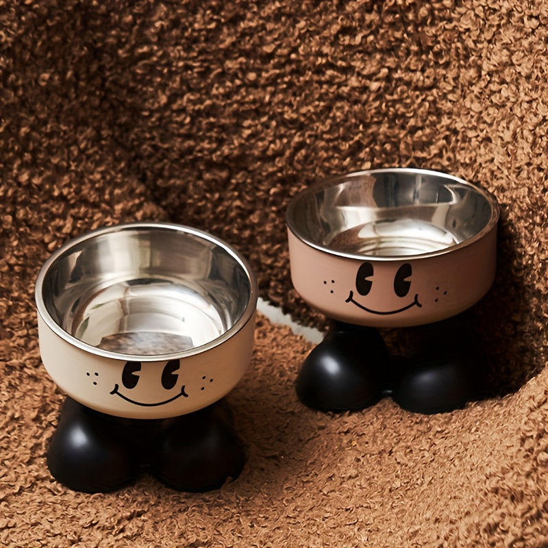 Thumbnail: Two elevated stainless steel pet bowls with smiley faces.