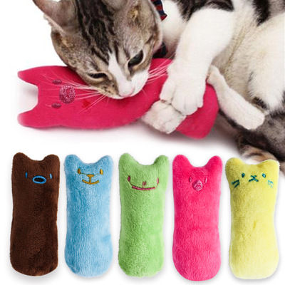 Cat chewing a pink plush catnip toy with others shown below.