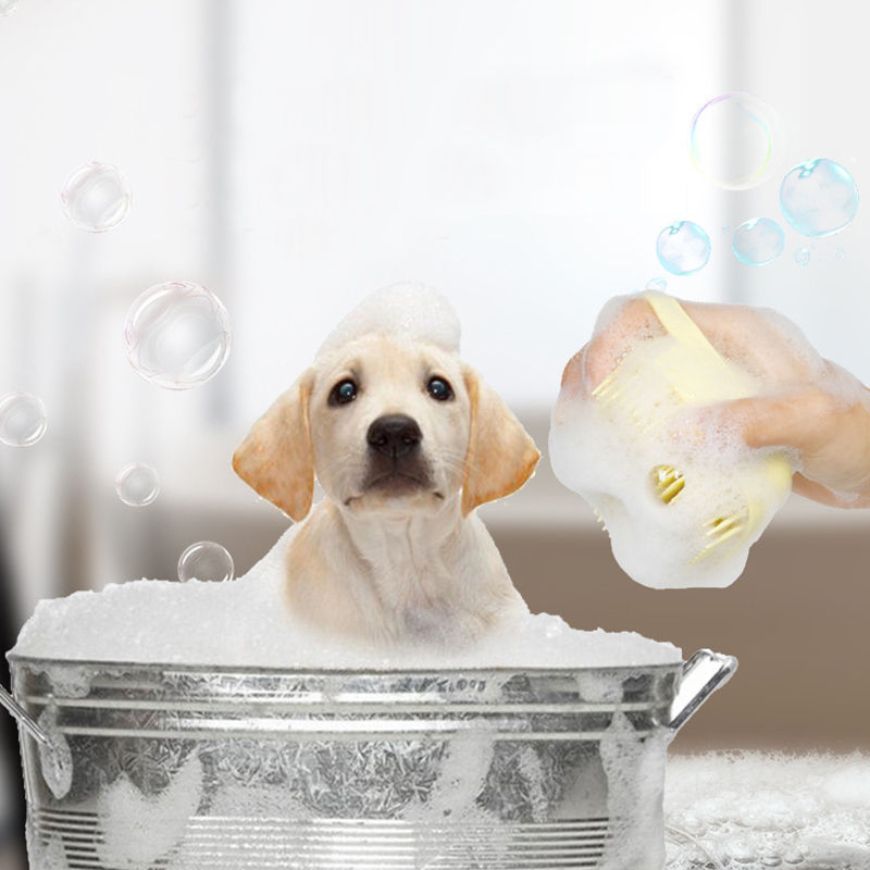 Yellow Labrador puppy in a bubble bath being groomed with a silicone massage brush.