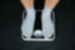 person weighing themselves on a scale