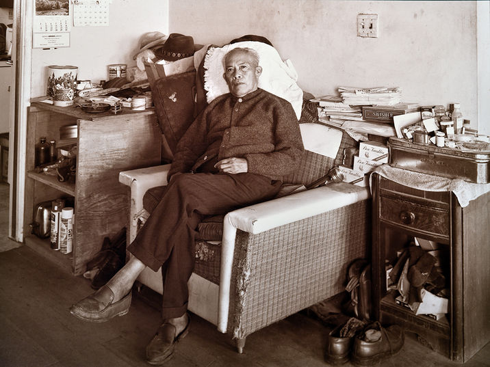 George Catalan Filipino farmworker relaxing on his living room chair, sweater and personal items.