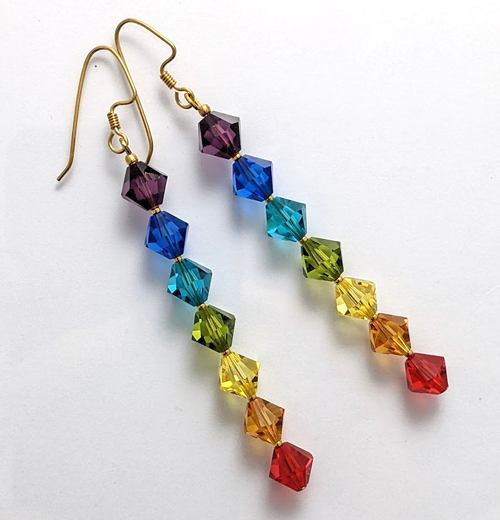 Long rainbow chakra earrings with square Austrian crystals in a vertical line and gold-plated hooks on a white background.