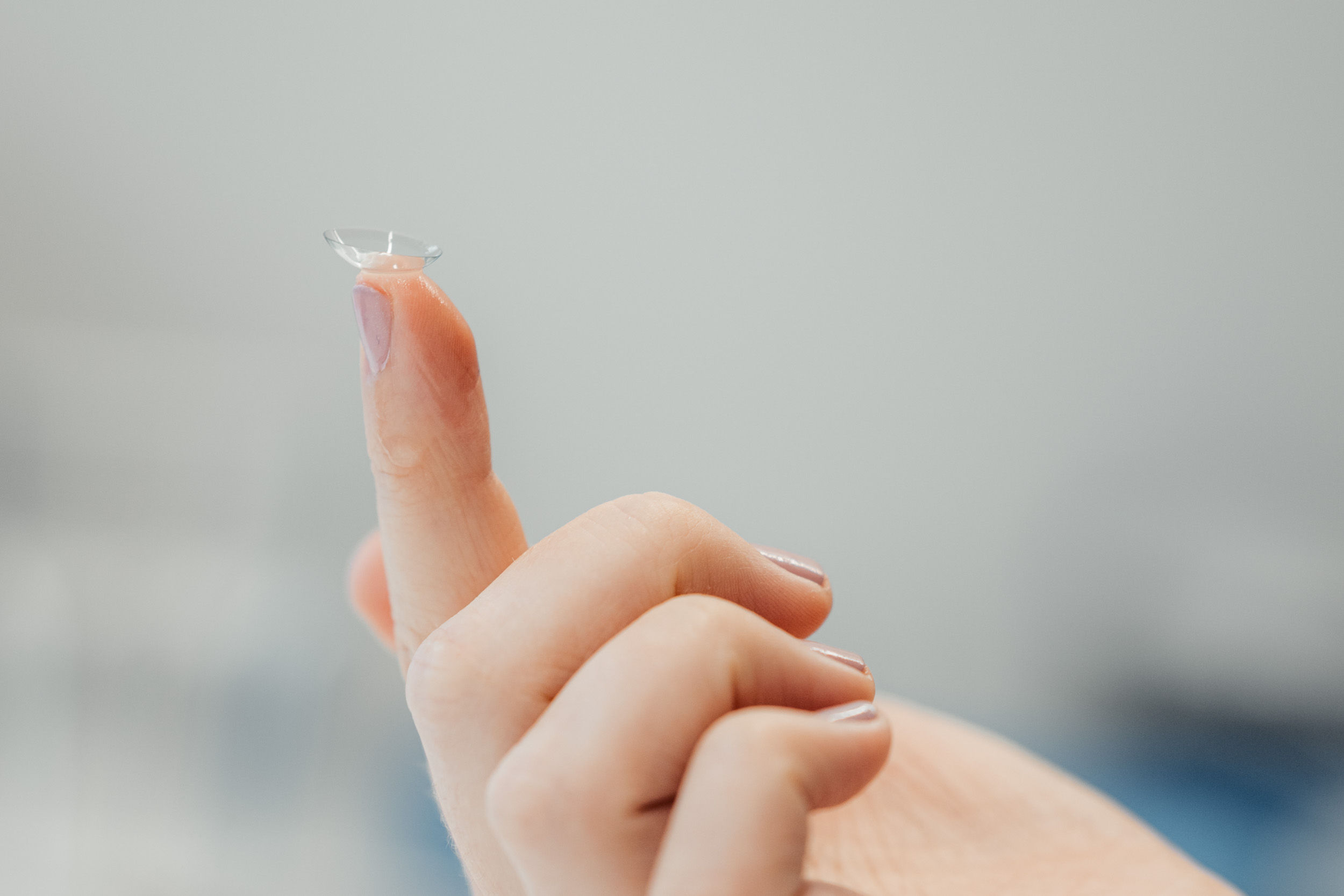 Hand öffnet Blisterpackung mit Kontaktlinse – hygienische Vorbereitung beim Optiker.