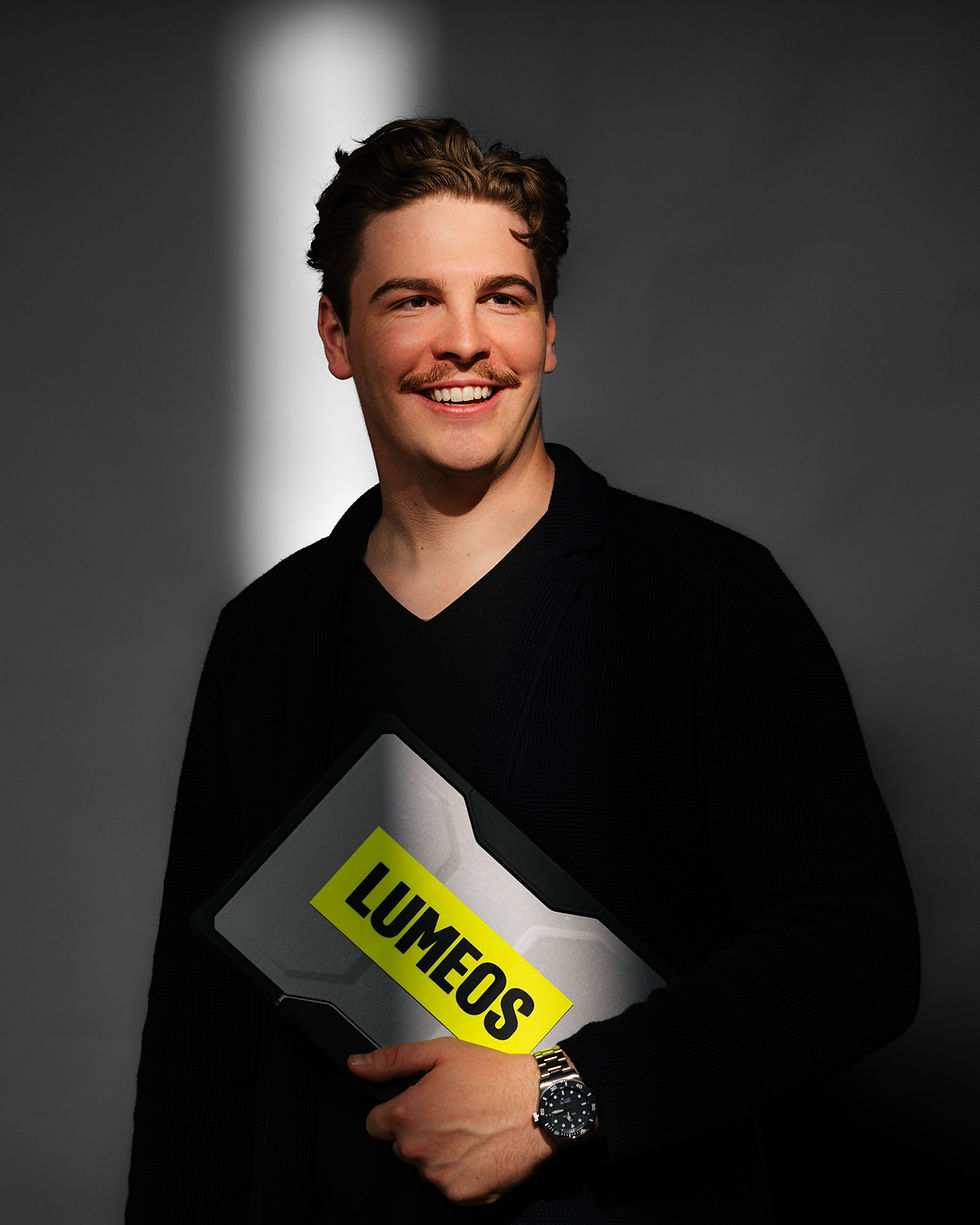 Portraitbild (bewegt) von Eric Frei in schwarzer Kleidung, Lichtschein im Hintergrund