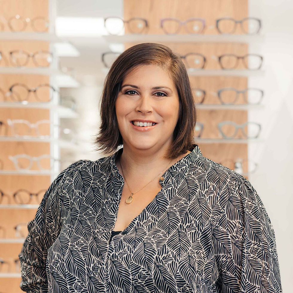 Portrait von Sandra Peter, im Hintergrund Brillen auf Holzgestellen