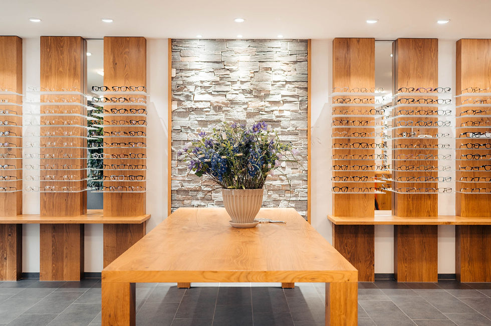 Holztisch in der Mitte des Geschäfts, darauf eine grosse Vase mit Blumen