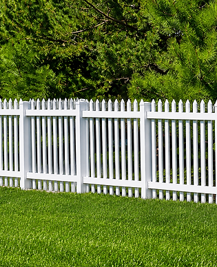 white vinyl picket fence surrounded by green vegetation in Ocala, Florida