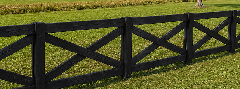 Decorative black crossbuck horse fence bordering a green pasture in Newberry, Florida — Penrod Lumber & Fence serving Ocala and North Central Florida
