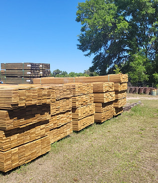 Stacked premium lumber at Penrod Lumber & Fence yard in Ocala, Florida — posts, rails, and custom fencing materials
