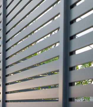 Modern gray horizontal slat commercial fence installed by Penrod Lumber & Fence in Ocala, Florida