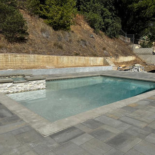 Modern pool installation in Rancho Mirage with stone decking and jacuzzi spa
