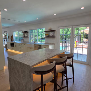 Luxury modern kitchen remodel in Rancho Mirage featuring custom island with waterfall Taj Mahal quartzite countertop and high-end finishes
