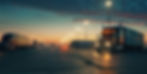 Trucks and trailers in a parking lot at dusk