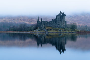 Kilchurn Castle Ruine in Schottland an einem nebligen See.