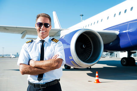 Confident pilot. Confident male pilot in uniform keeping arms crossed and smiling with air