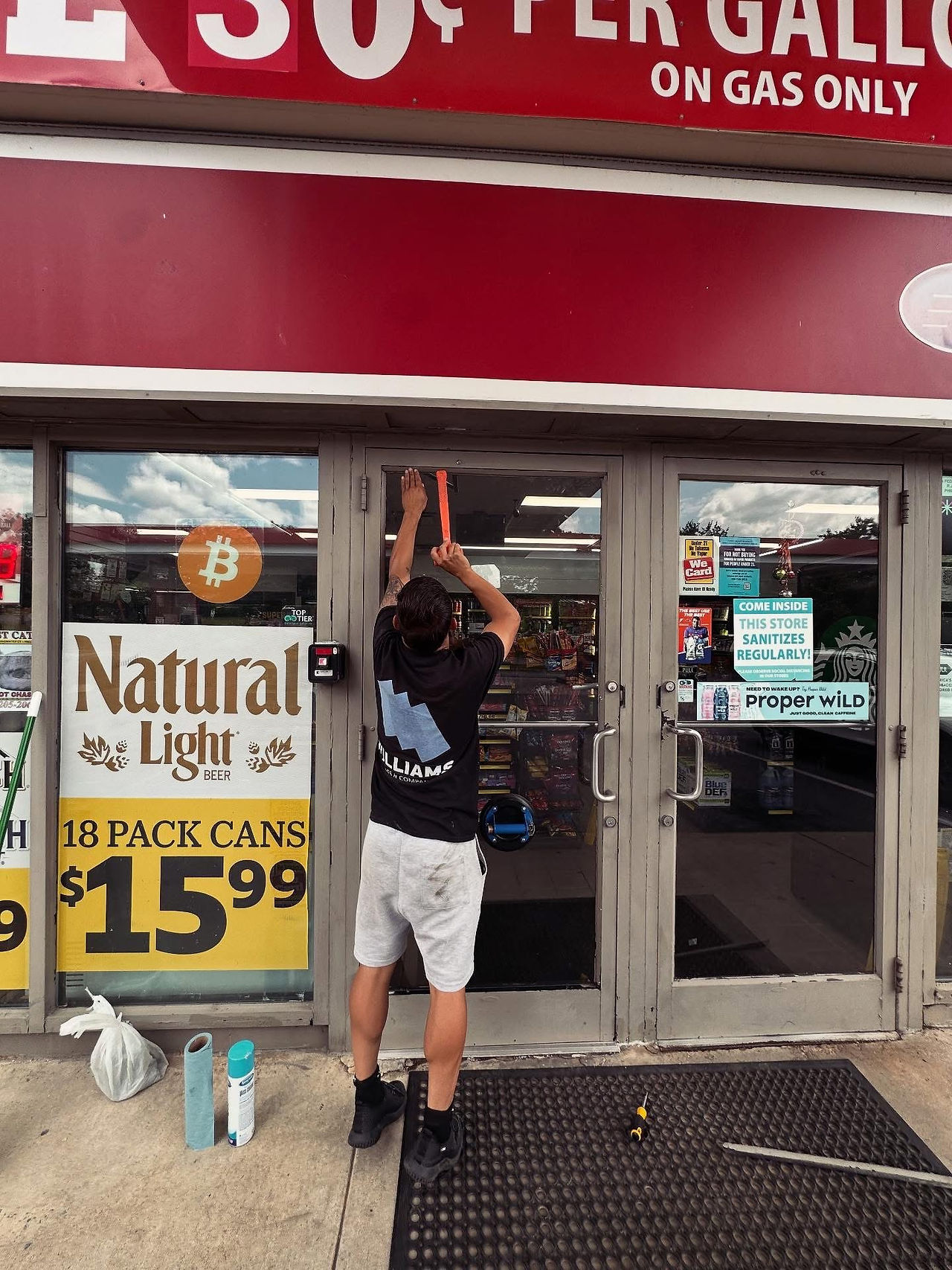 Technician installing top gaskets for storefront door glass