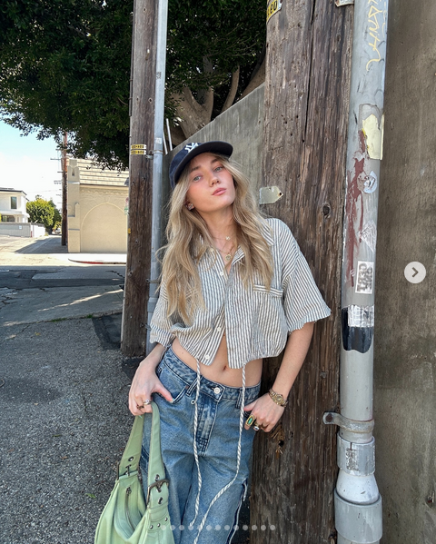 Young blonde girl modeling The Council Shop thrift store clothes stylishly outside.