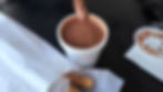 Churros Calientes rich cup of hot chocolate with churro being dipped in.