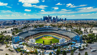 March 2025 in Los Angeles Cover Photo with Dodger Stadium as the focus in front of DTLA skyline on a bright sunny day.