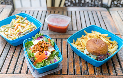 Salad, burgers and fries, pasta, and red sauce in Friendlier reusable containers