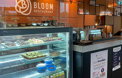 Display case with baked goods and meals in Friendlier containers at Bloom Restaurant
