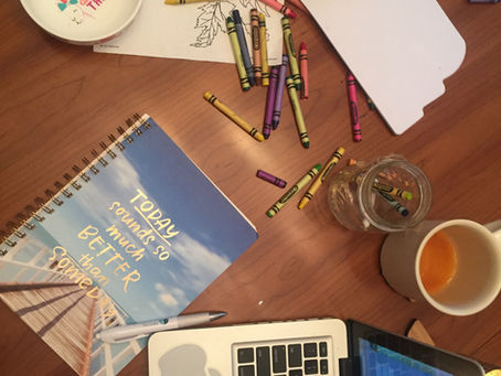 Picture of a journal with a pretty beachy dock and the words "Today sounds so much better than someday." The table is a mess with crayons and coffee half finishd