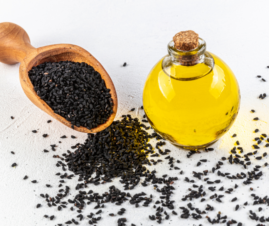 Black cumin seed spilled on table and black cumin seed oil in a jar