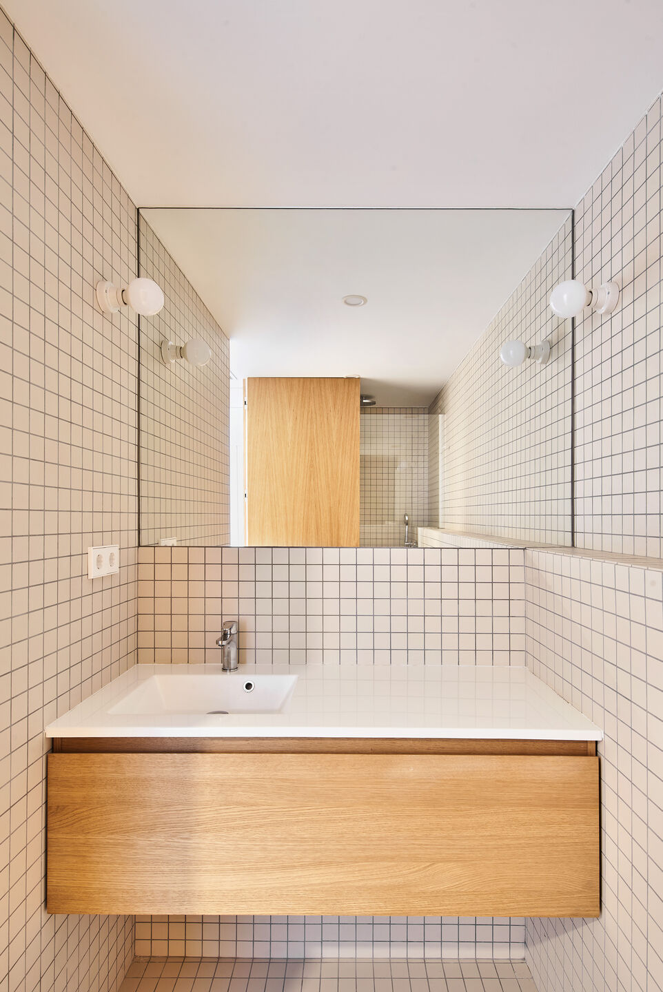 Kare beyaz seramik duvar ve zemin kaplaması olan, banyo dolabı ve banyo aynası olan, ahşap banyo dolabı, gömme lavabo olan banyo tasarımı