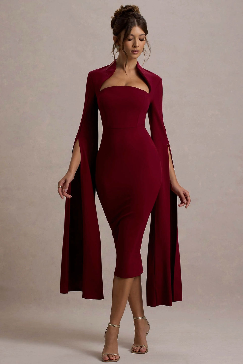 Nocté Drape Maxi Dress featuring a bodycon silhouette, dramatic cape sleeves, and high neckline in rich tones.