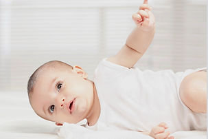 Baby beginning to roll over, a common sign that it's time to transition out of the swaddle.