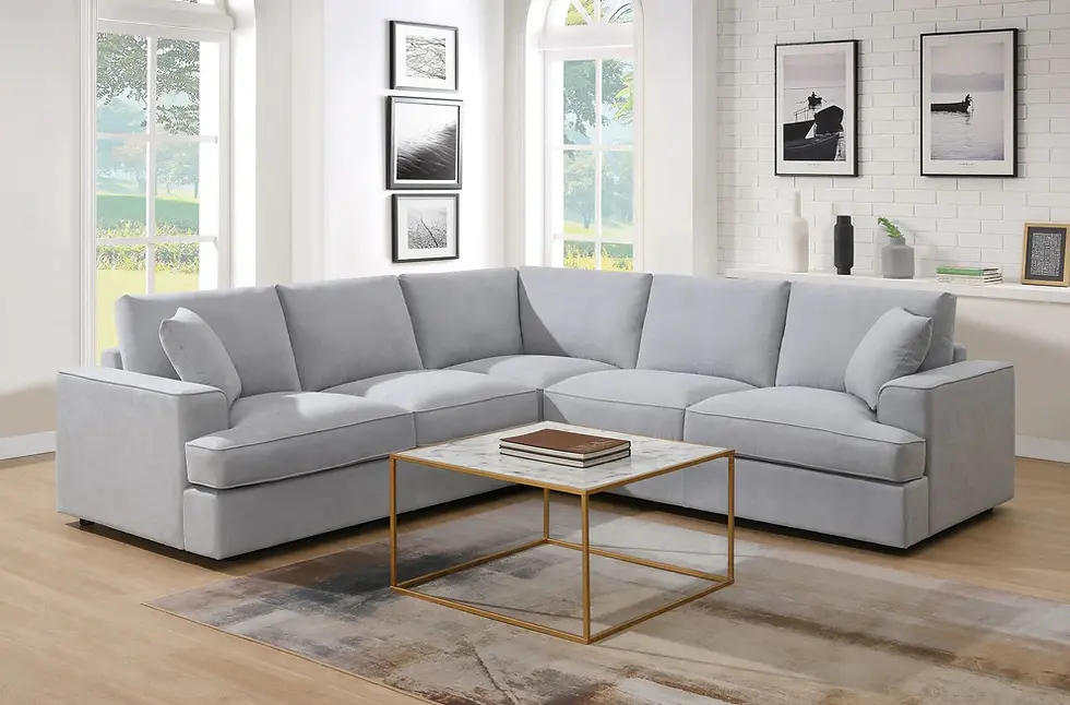Light grey sectional sofa, marble coffee table in bright living room.