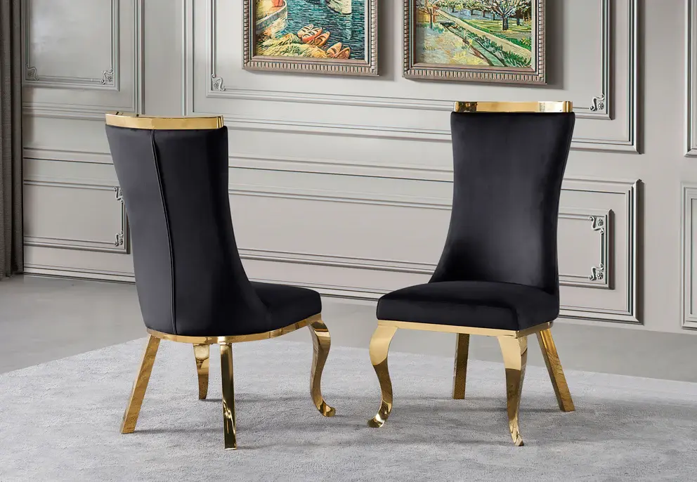 Two elegant black velvet dining chairs with golden legs.