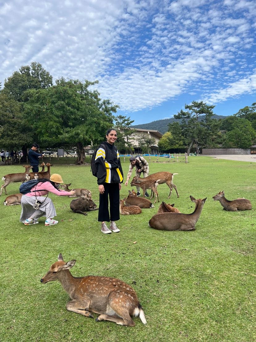 Woman standing with deer in Nara