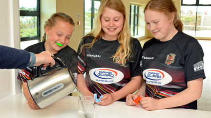 Children moulding a boil-and-bite Game Guard gumshield for a secure, comfortable fit in school sports