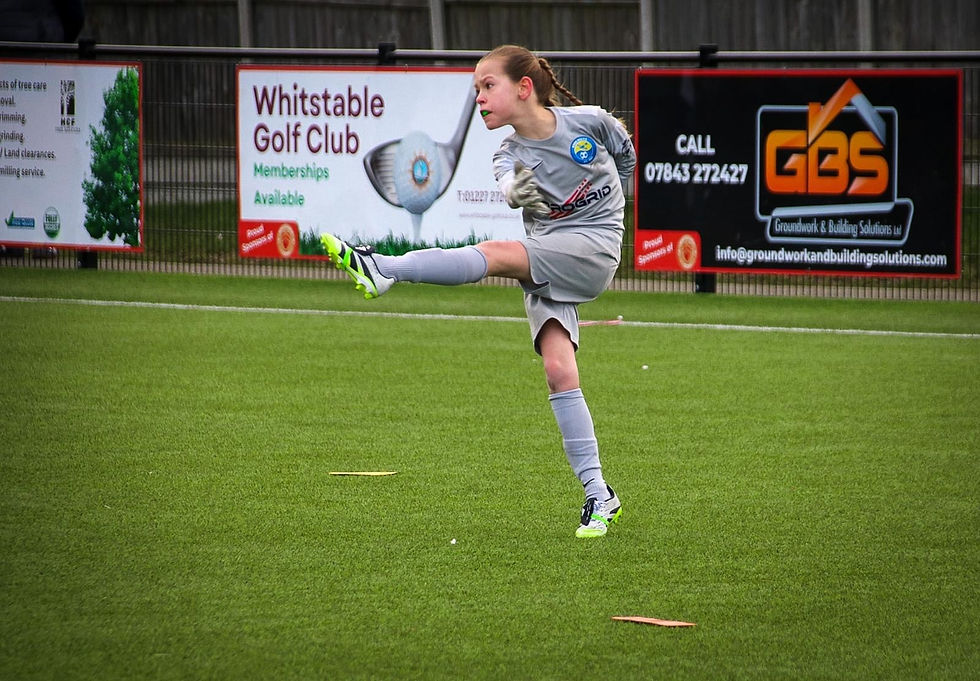 Youth football player wearing a green gumshield kicking the ball during a match, demonstrating safe sports protection for children