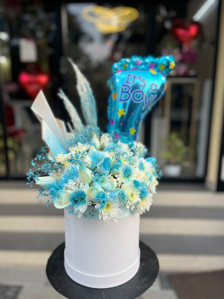 a stunning arrangement of mixed roses,chrysanthymums,  lilies, and foil balloon.