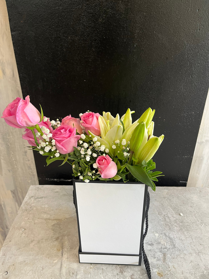 A beautiful Mixed Bouquet of pink roses and lilies in a rectangular box.