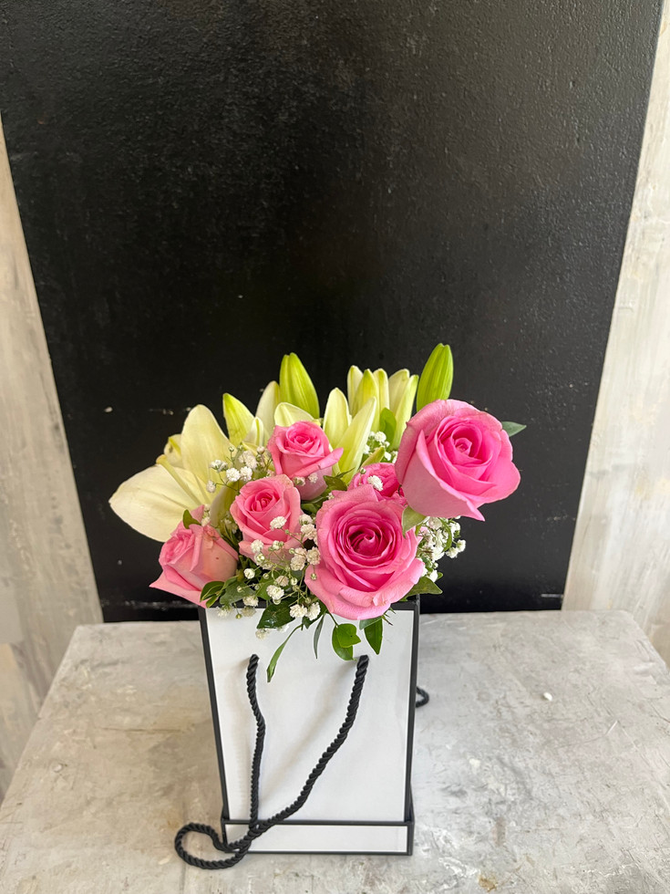 A beautiful Mixed Bouquet of pink roses and lilies in a rectangular box.