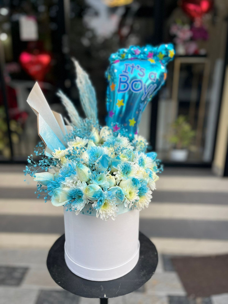 a stunning arrangement of mixed roses,chrysanthymums,  lilies, and foil balloon.