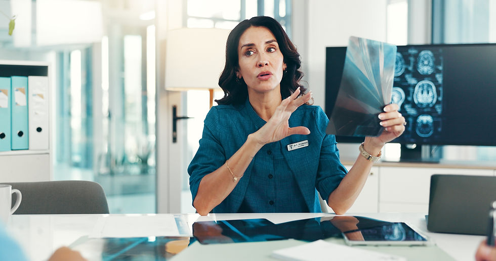 A female neurologist reviews brain MRI scans with a patient in a clinical office, reflecting the importance of choosing the right neurologist for you.