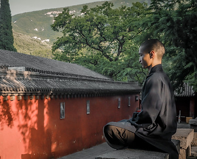 Shaolin Mönch meditiert auf einer Bank im Shaolin Tempel