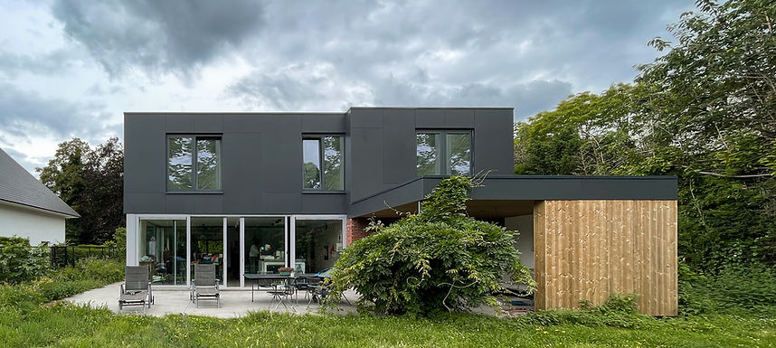 In dit project werd de huidige woning opgetopt om meer ruimte te creëren op de verdieping. Deze optopping is gerealiseerd in houtskeletbouw, waardoor het gewicht van de constructie beperkt blijft en de bestaande fundering niet verzwaard hoeft te worden. De strakke gevel contrasteert met de baksteen en de houten gevelafwerking achteraan. Binnen zorgt het vele hout voor een warme toets. 