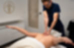 Person relaxing in a minimalist wellness studio with soft ambient lighting and organic textures