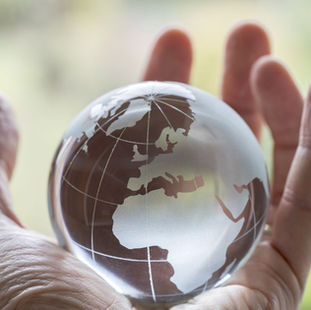 A human hand holding the globe
