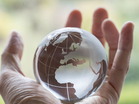 A human hand holding the globe