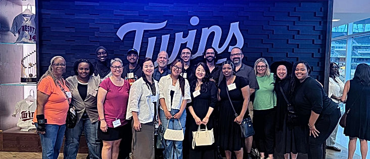Photo of Deaf Equity group in front of MN Twins sign at the Twins baseball game.